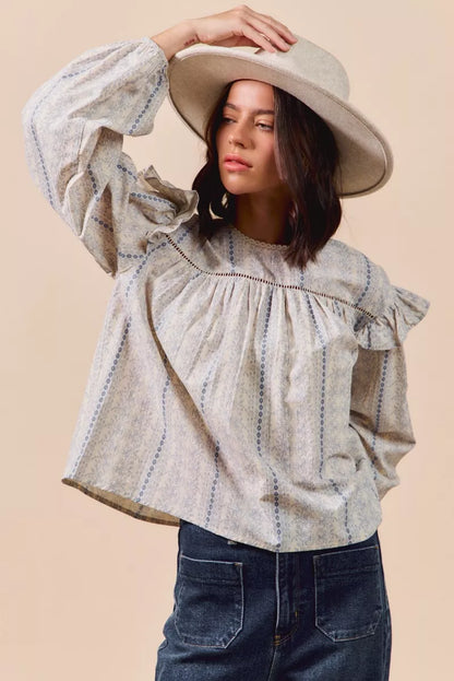 Blue floral cotton print ruffled long sleeve blouse by Trendsi, featuring a feminine design and lightweight fabric.