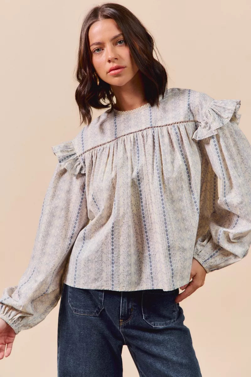 Blue floral cotton print ruffled long sleeve blouse from SO ME by Trendsi, featuring feminine ruffle details and lightweight fabric.