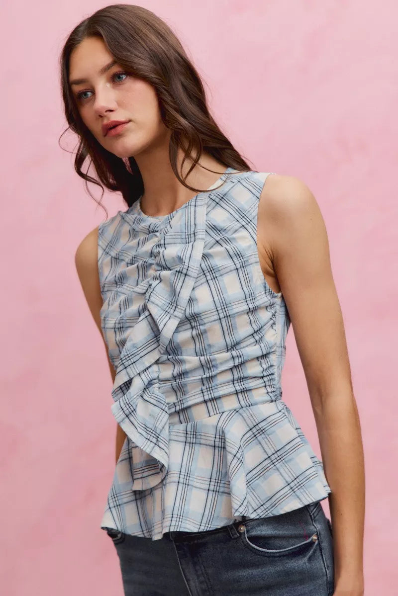 Blue plaid sleeveless ruffle peplum top from SO ME by Trendsi, displayed on a hanger showing the ruffle details and peplum style.