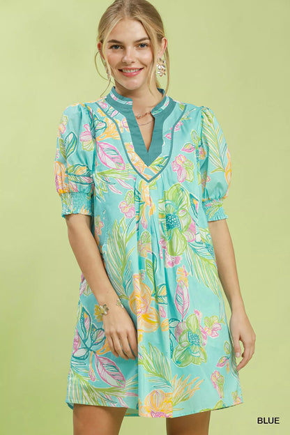Blue Umgee botanical print dress with smocked cuffs, featuring a flowy silhouette and vibrant floral pattern.