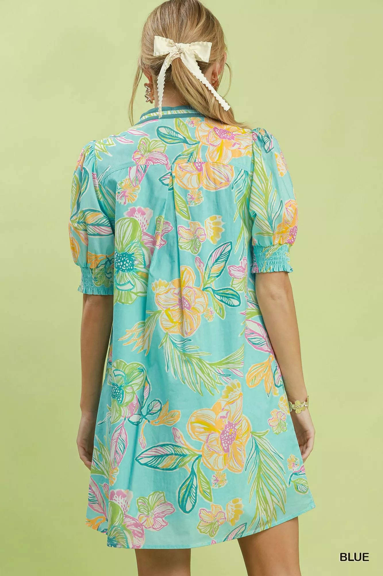 Blue Umgee botanical print dress with smocked cuffs, featuring a flowing design and floral pattern, styled for casual wear.