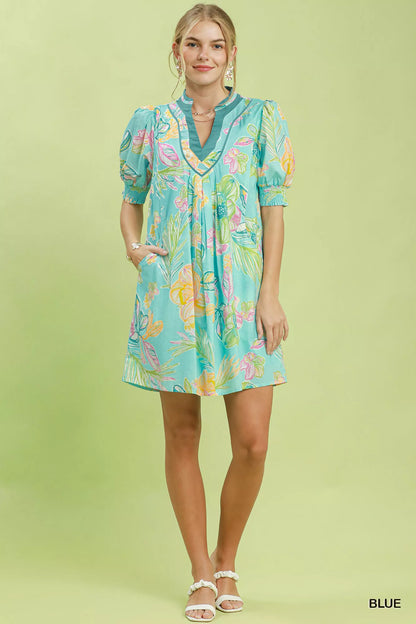 Blue Umgee botanical print dress with smocked cuffs, featuring a flowy silhouette and stylish floral pattern.