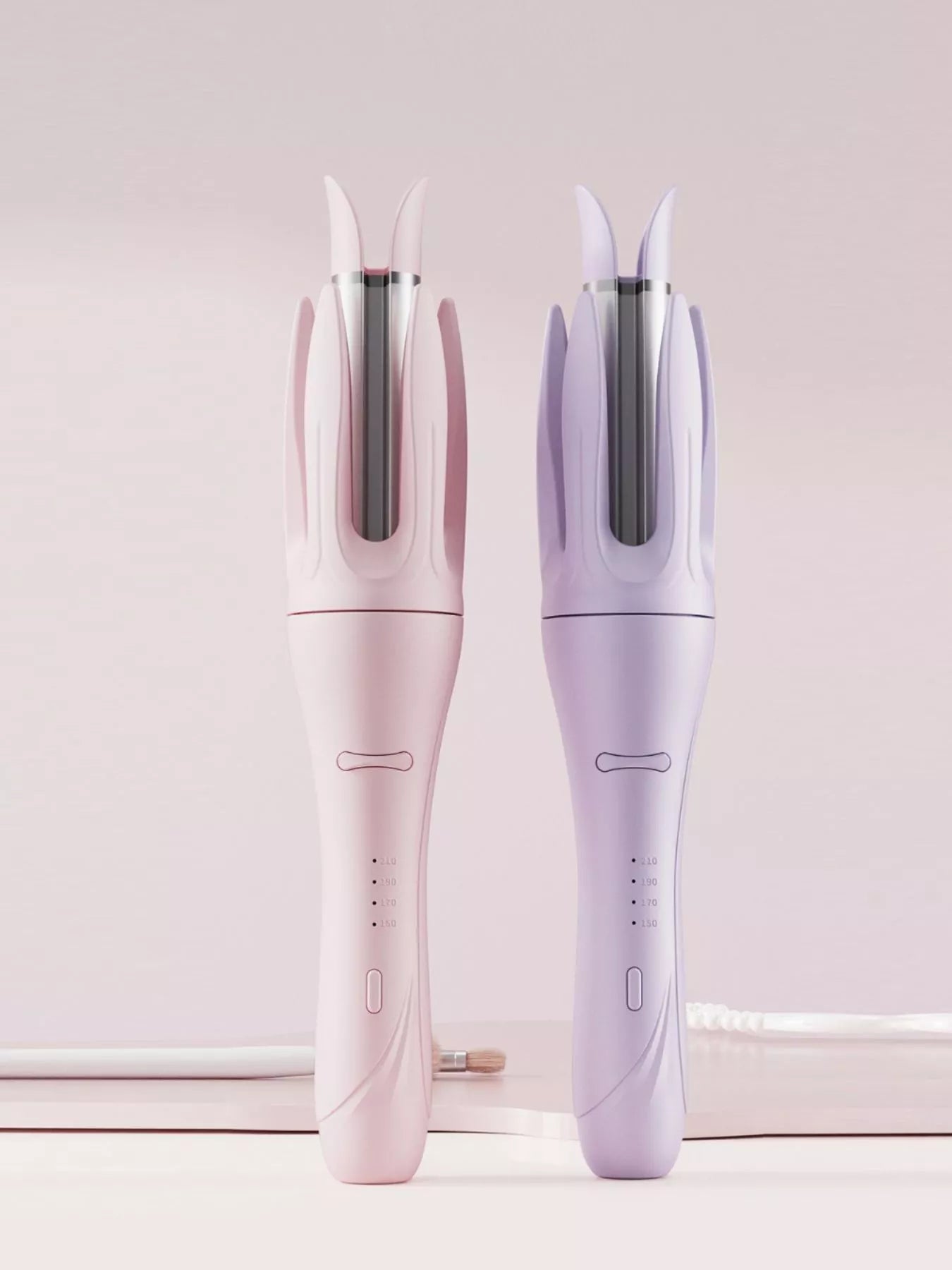 Blush pink automatic rotating ceramic curling iron with European plug by Trendsi, showcasing its sleek design and rotating barrel.