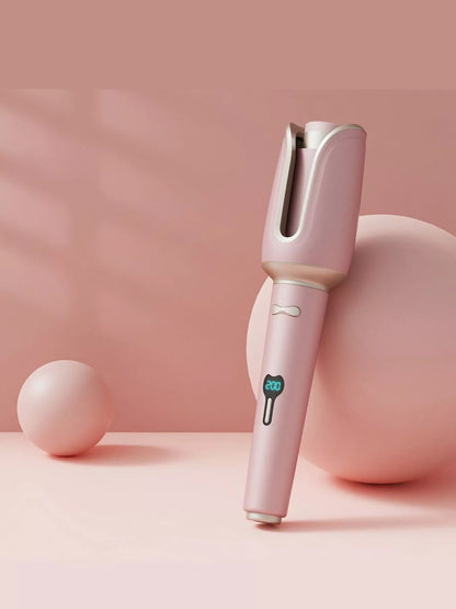 Blush pink automatic rotating ceramic hair curling iron with European plug by Trendsi, showing the curling barrel and handle.