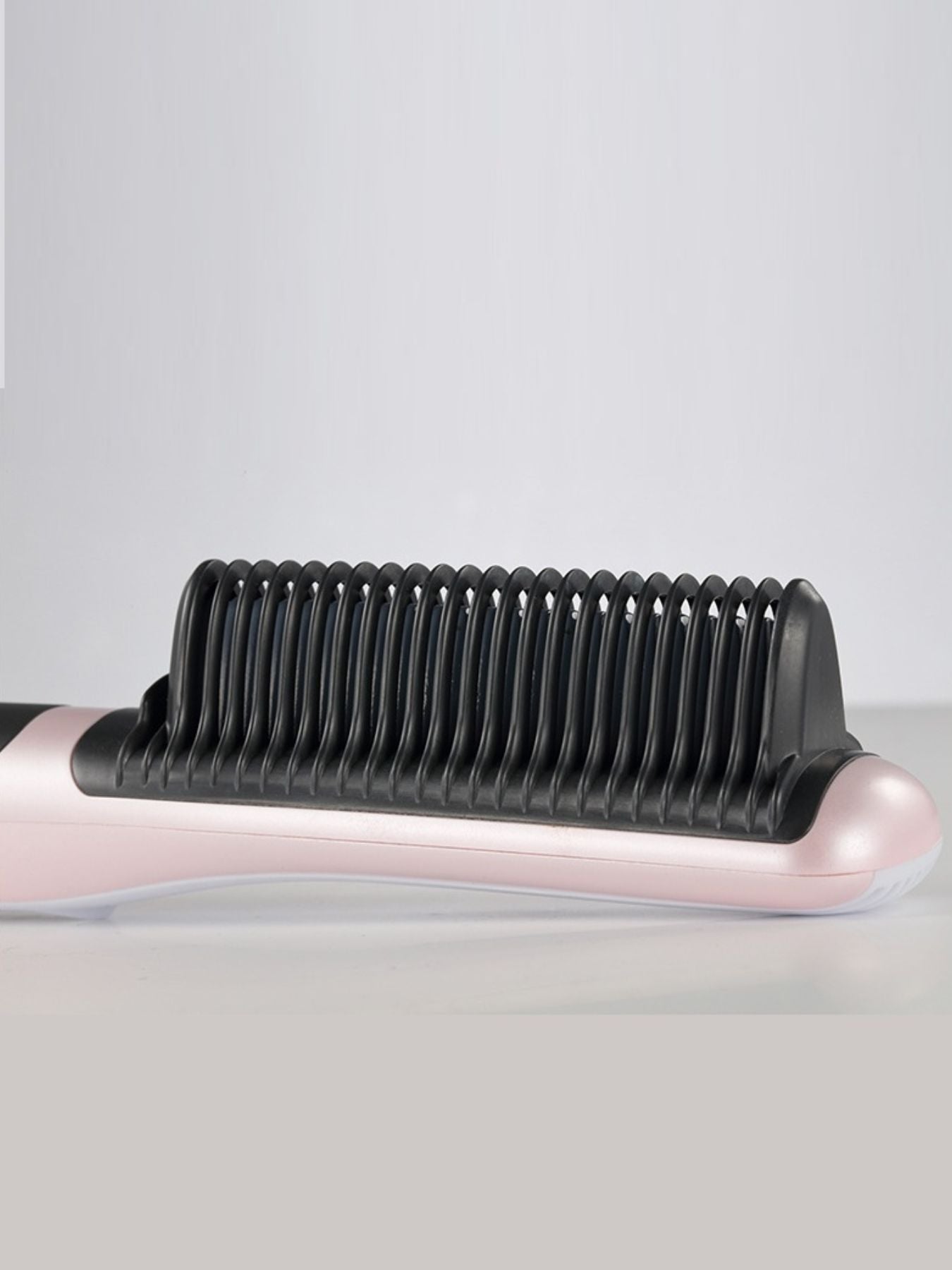 Blush pink heated hair straightening comb by Trendsi with North American plug, designed for smooth, straight hair styling.