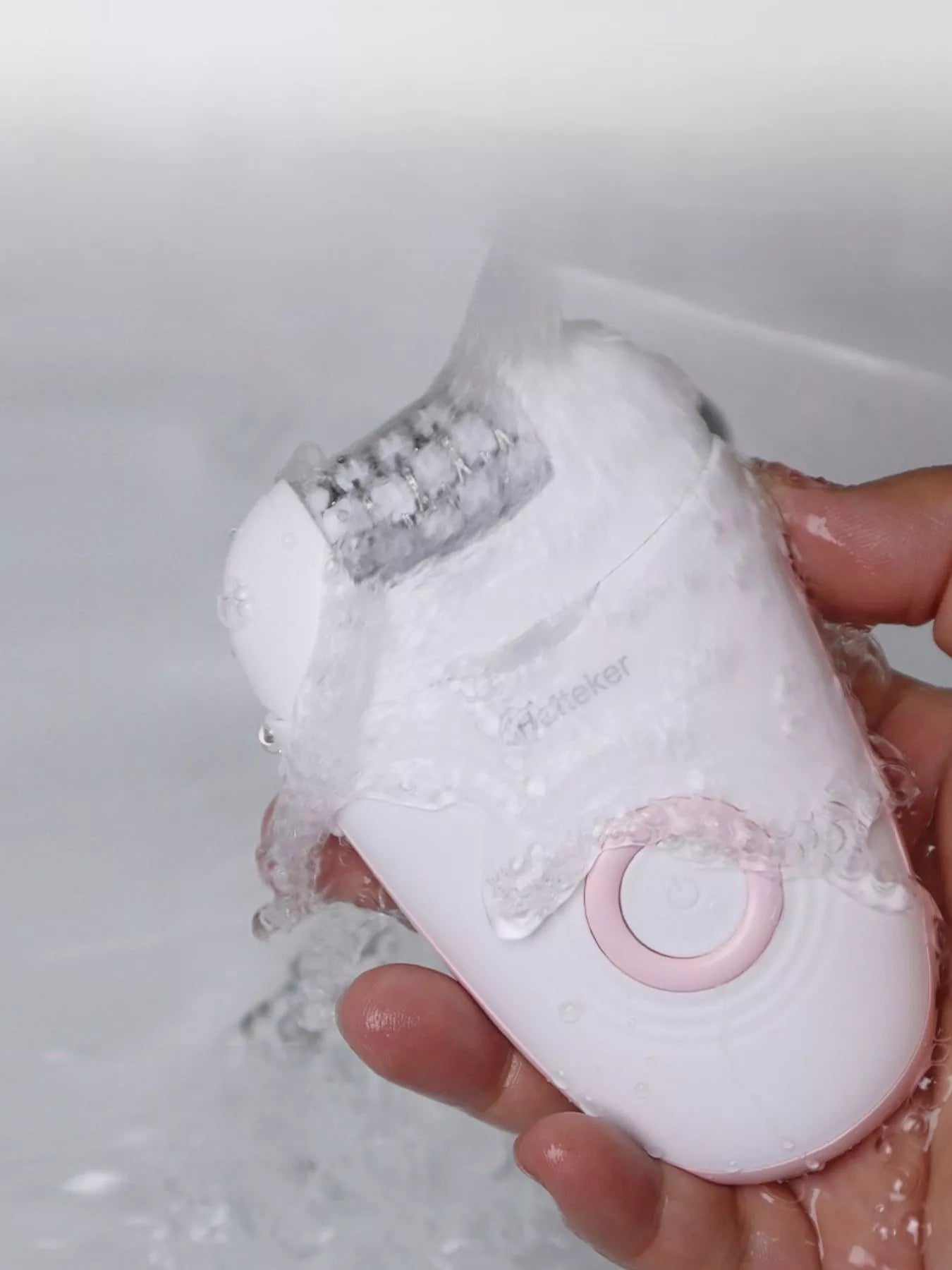 Blush pink portable hair removal epilator by Trendsi, compact design with multiple attachment heads for easy hair removal.