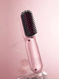 Blush pink portable heated straightening comb by Trendsi, compact design for easy hair styling and straightening.