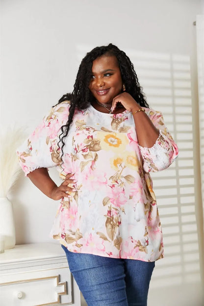 Blush pink floral round neck top with three-quarter sleeves by Trendsi, showcasing a stylish casual design.
