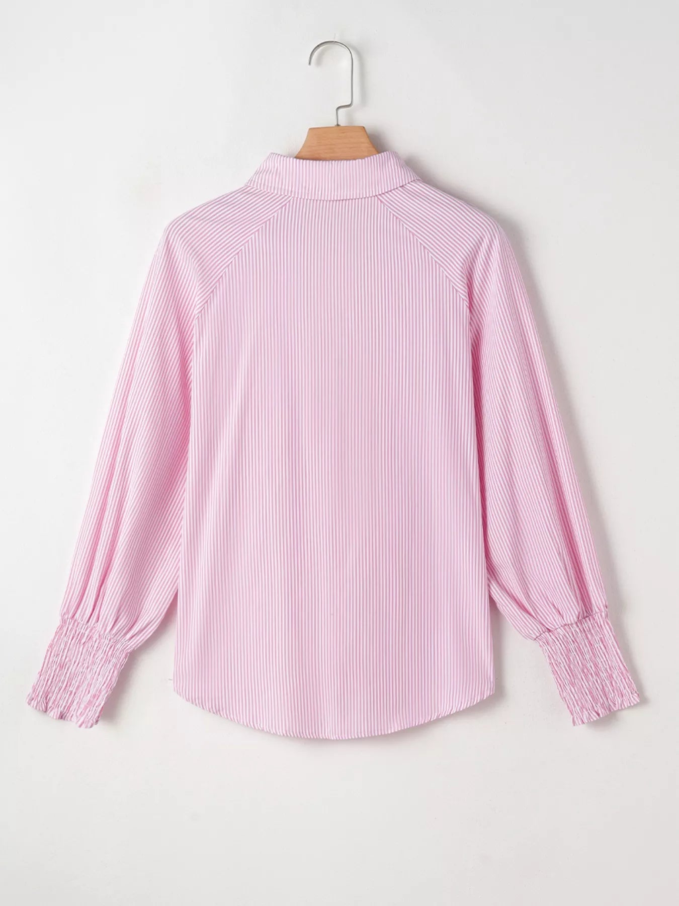 Blush pink pinstripe long sleeve blouse with smocked cuffs, button front, and shirt collar from Trendsi.
