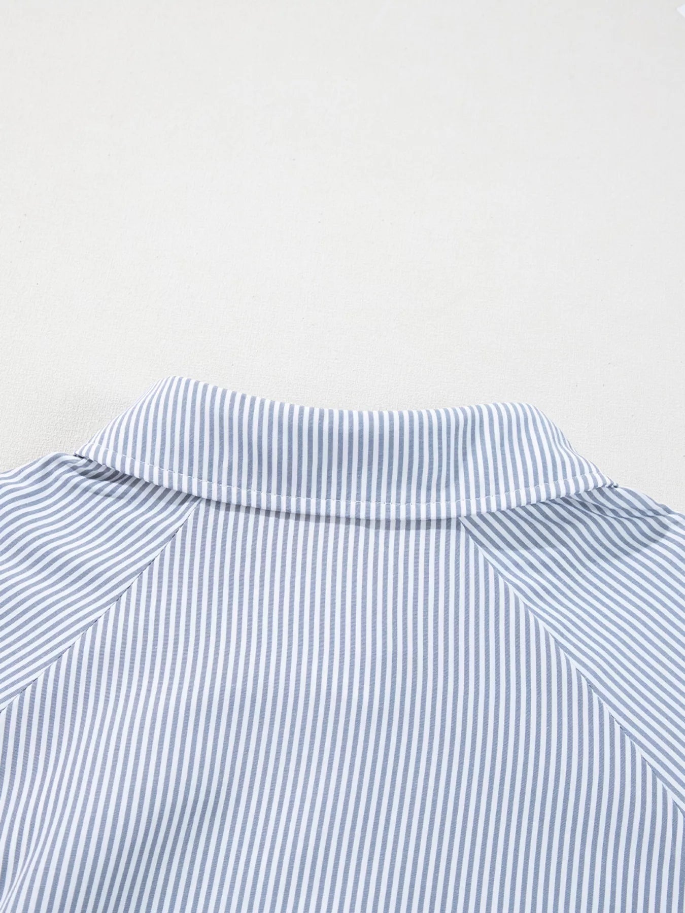 Blush pink pinstripe long sleeve blouse with smocked cuffs, button front, and shirt collar from Trendsi.