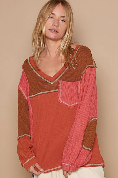 Brick-colored POL V-neck knit top with panel design and exposed seams by Trendsi, shown on a model.