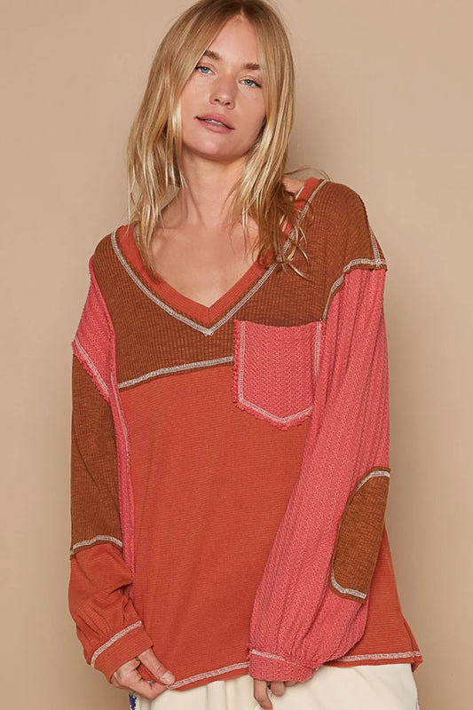 Brick-colored POL V-neck knit top with panel design and exposed seams by Trendsi, shown on a model.