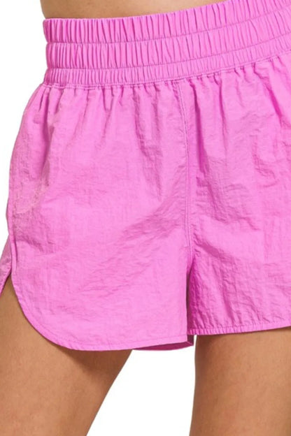 Bright mauve Zenana windbreaker running shorts with smocked waistband, designed for comfort and active wear.