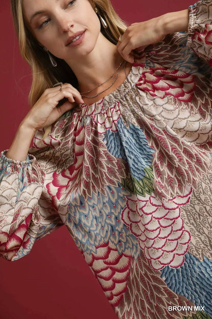 Brown Umgee boho feather print peasant blouse with long sleeves and relaxed fit, styled on a model.