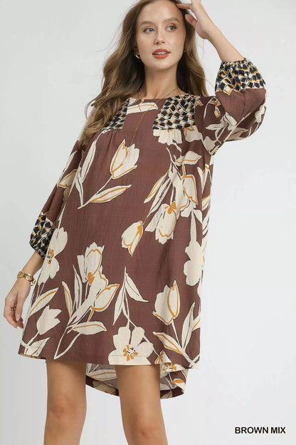 Brown floral high-low babydoll dress by Umgee, featuring a flowy silhouette and floral pattern, perfect for casual or dressy occasions.