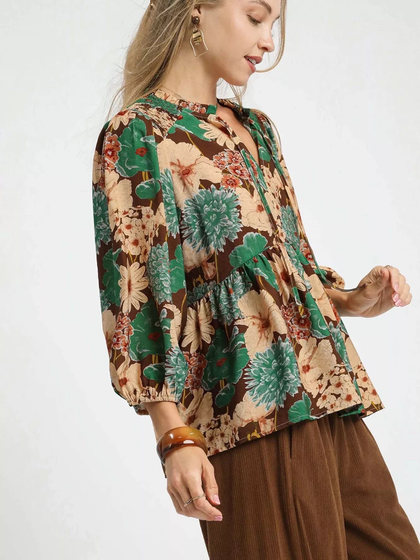 Trendsi Umgee floral peplum blouse with tie-neck in brown and mixed floral print, shown on a model.