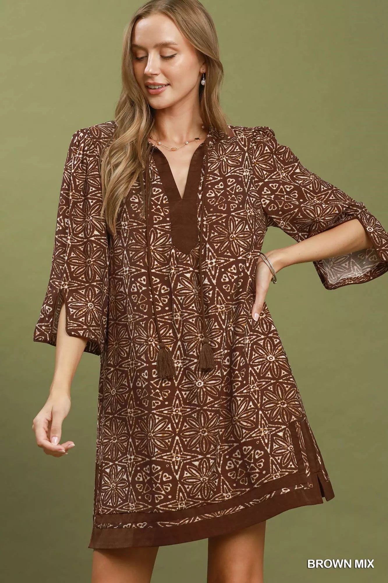 Umgee brown geometric print V-neck tunic dress with tassel detail, casual style, short sleeves, and relaxed fit.