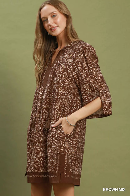Brown Umgee geometric print tunic dress with V-neck and tassel details, featuring a relaxed fit and stylish design.