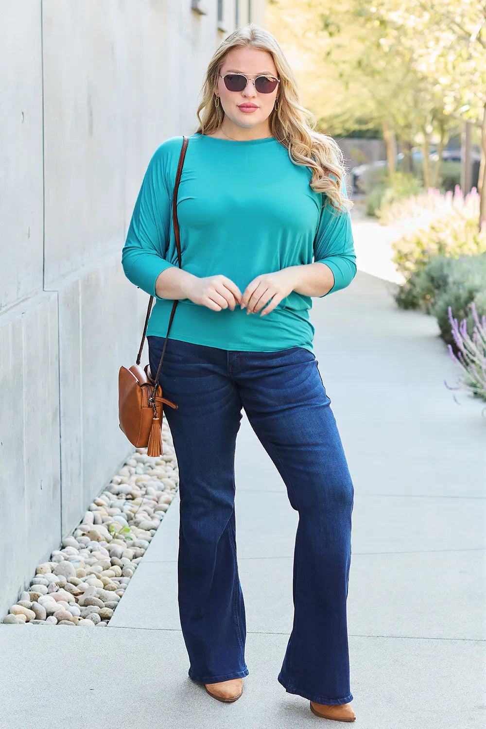 Brown Trendsi Basic Bae full-size round neck batwing sleeve top on a hanger, showcasing its relaxed fit and stylish design.
