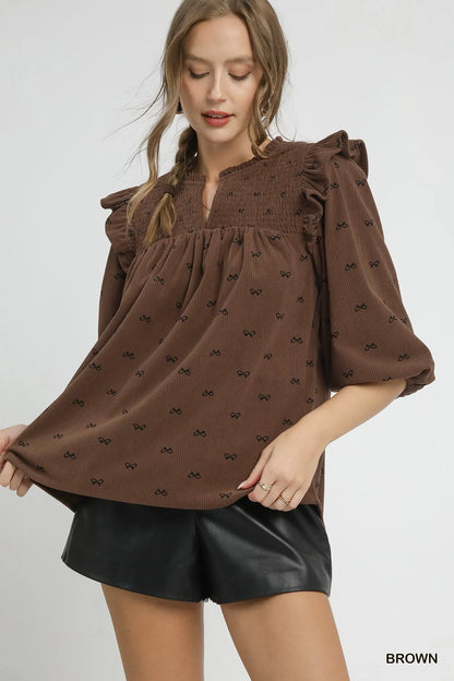 Brown Umgee bow print corduroy puff sleeve blouse with ruffled details, featuring a stylish and feminine design.
