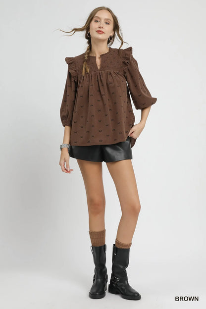 Brown Umgee bow print corduroy puff sleeve blouse with ruffled accents, featuring a stylish and vintage-inspired design.