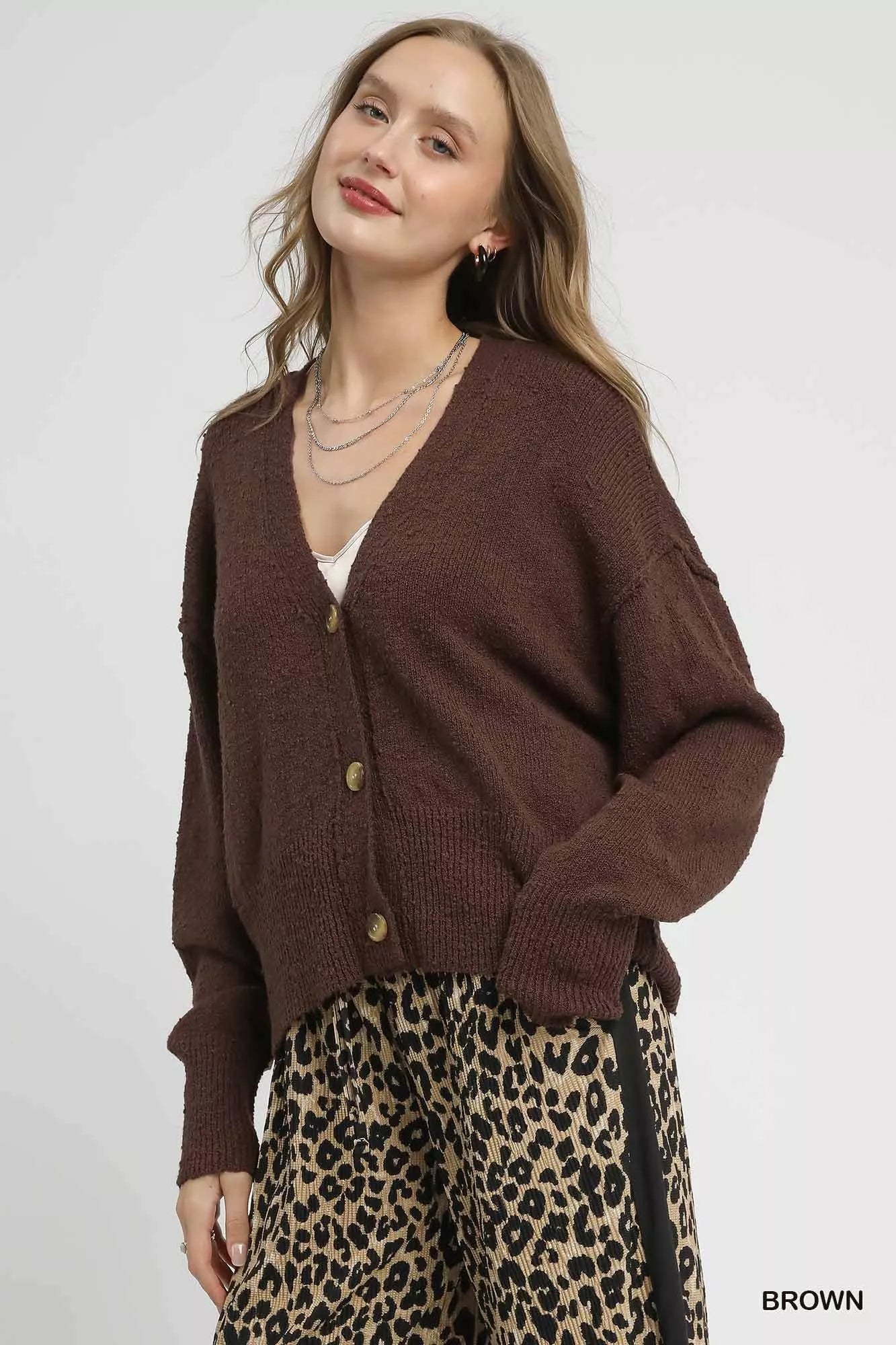 Brown Umgee button-front V-neck knit cardigan with long sleeves and ribbed cuffs, styled on a neutral background.