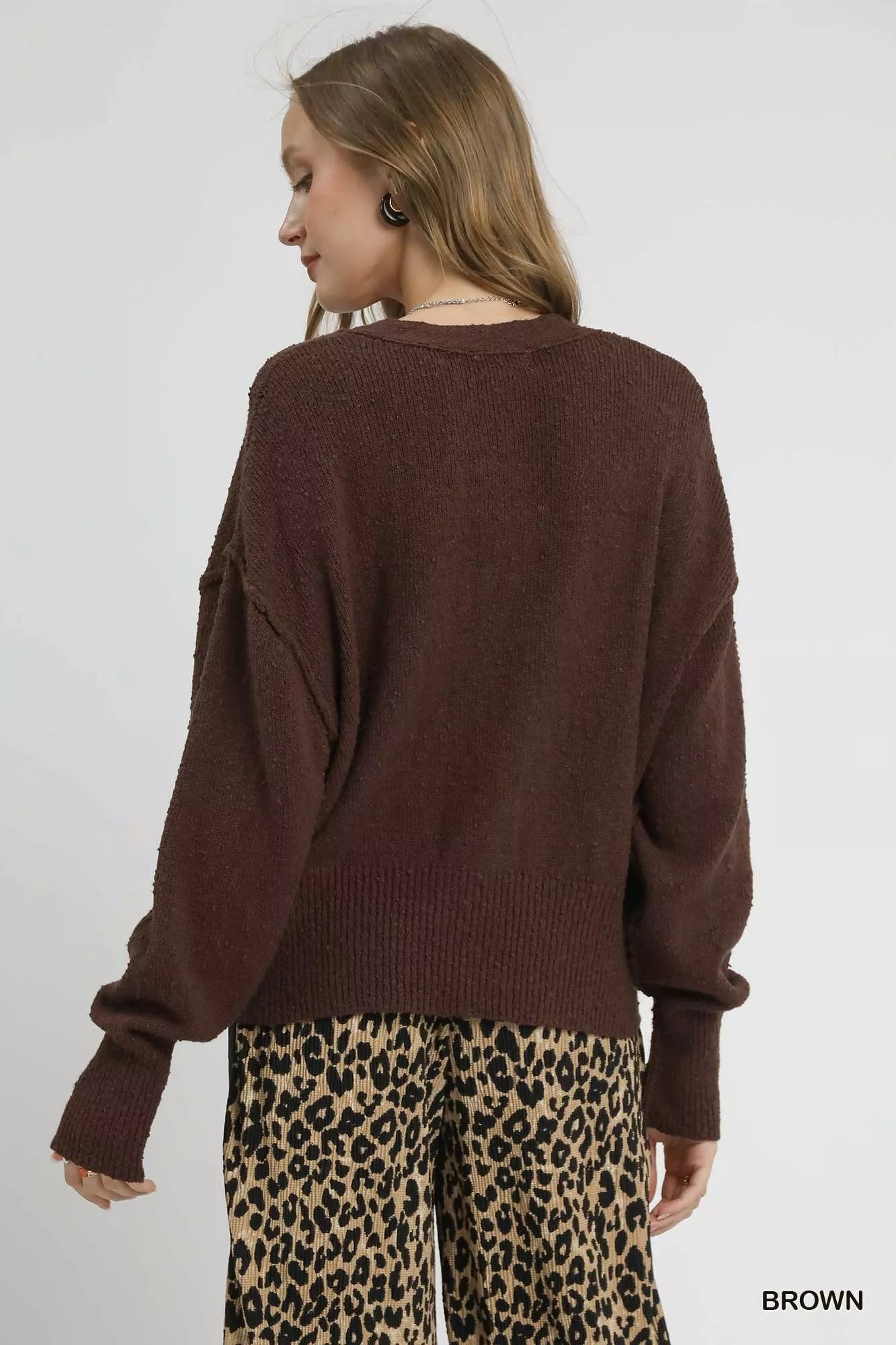 Brown Umgee button-front V-neck knit cardigan with long sleeves and ribbed cuffs, displayed on a hanger against a neutral background.