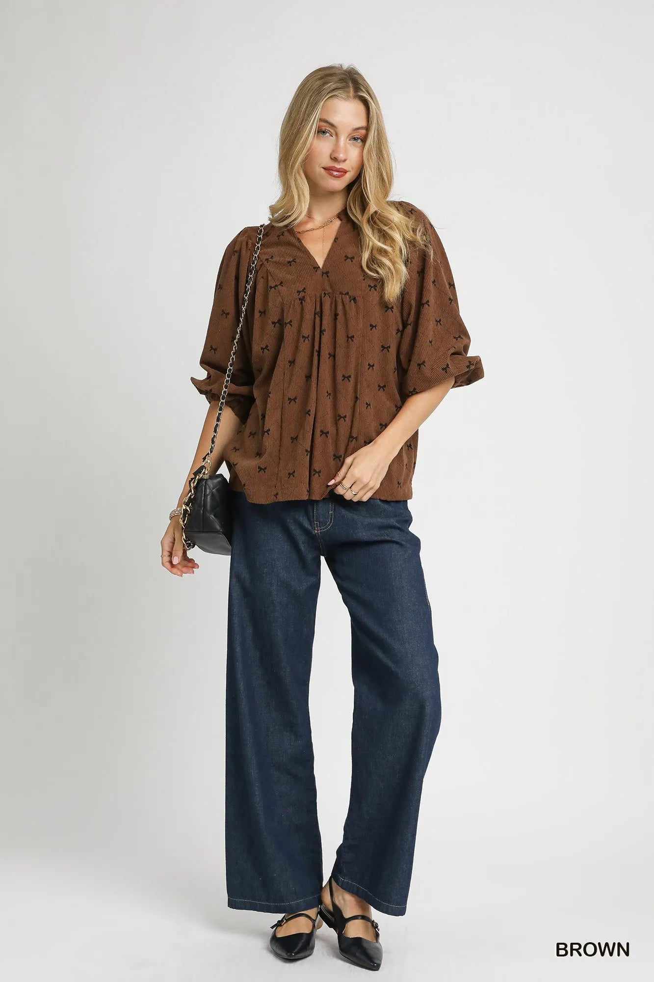 Brown Umgee corduroy balloon sleeve blouse with bow print and relaxed fit, featuring stylish balloon sleeves and button details.
