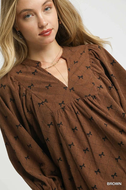 Brown Umgee corduroy blouse with bow print, balloon sleeves, and a relaxed fit, perfect for casual or stylish outfits.
