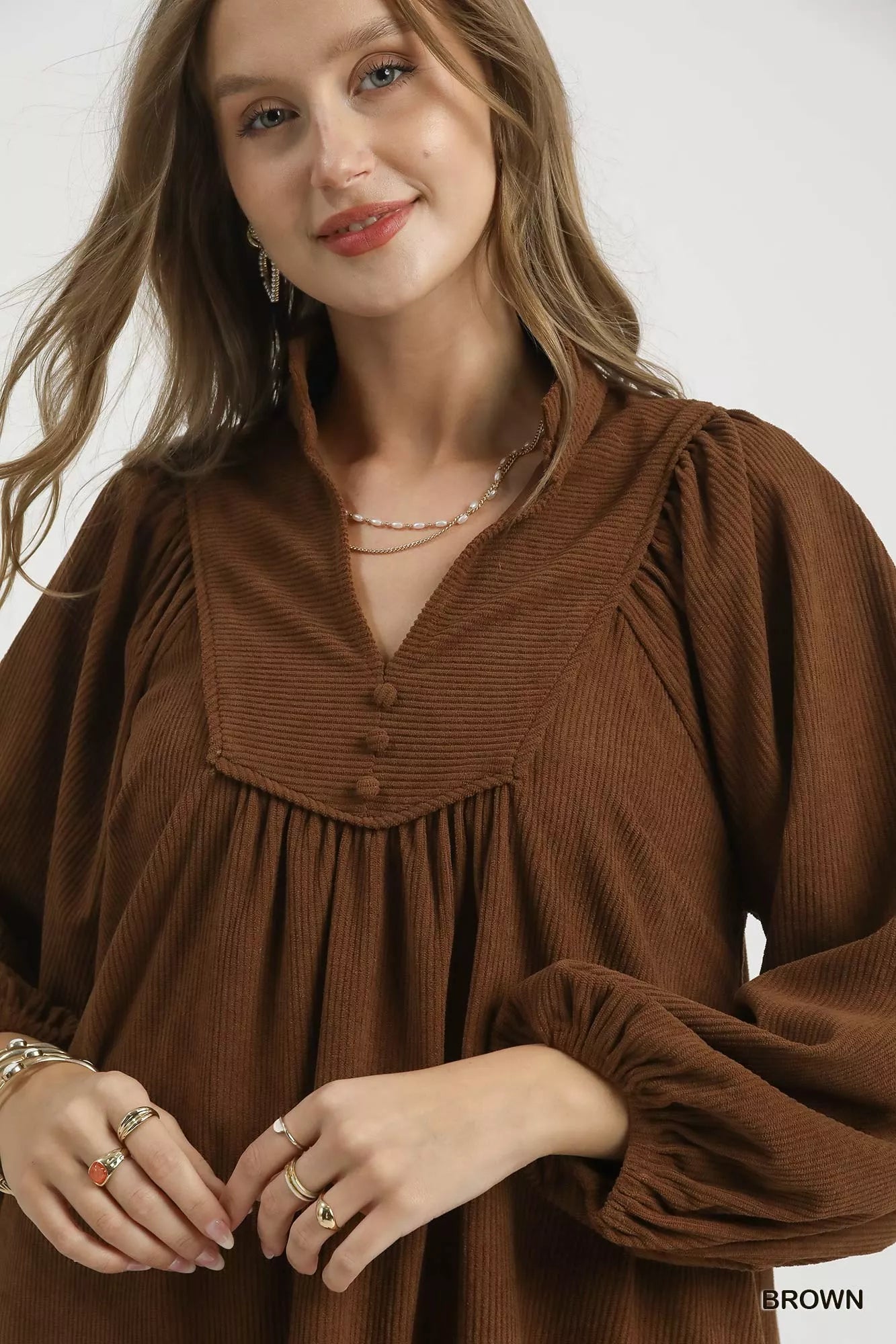 Brown Umgee corduroy tiered babydoll dress with long sleeves and a relaxed fit, styled for casual wear.