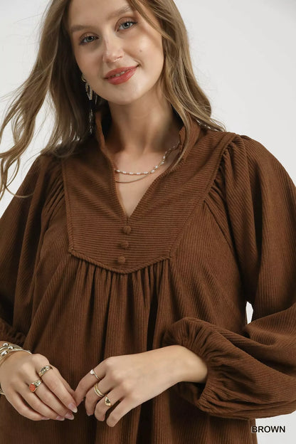 Brown Umgee corduroy tiered babydoll dress with long sleeves and a relaxed fit, styled for casual wear.