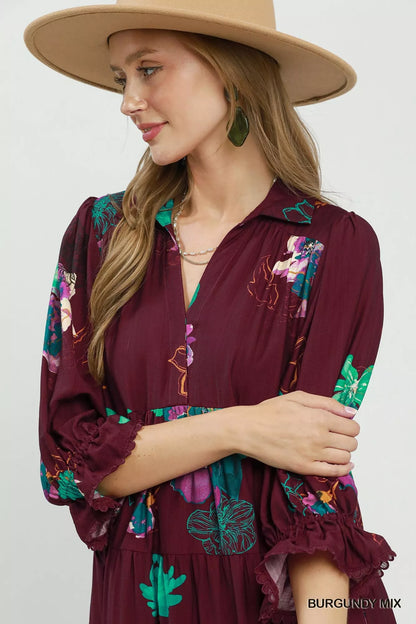 Burgundy floral print tiered midi dress with puff sleeves by Umgee, styled with ruffled details and a flowy silhouette.