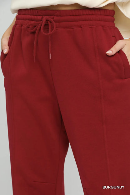 Burgundy Umgee fleece jogger pants with drawstring waist, featuring a relaxed fit and soft fabric for comfortable casual wear.