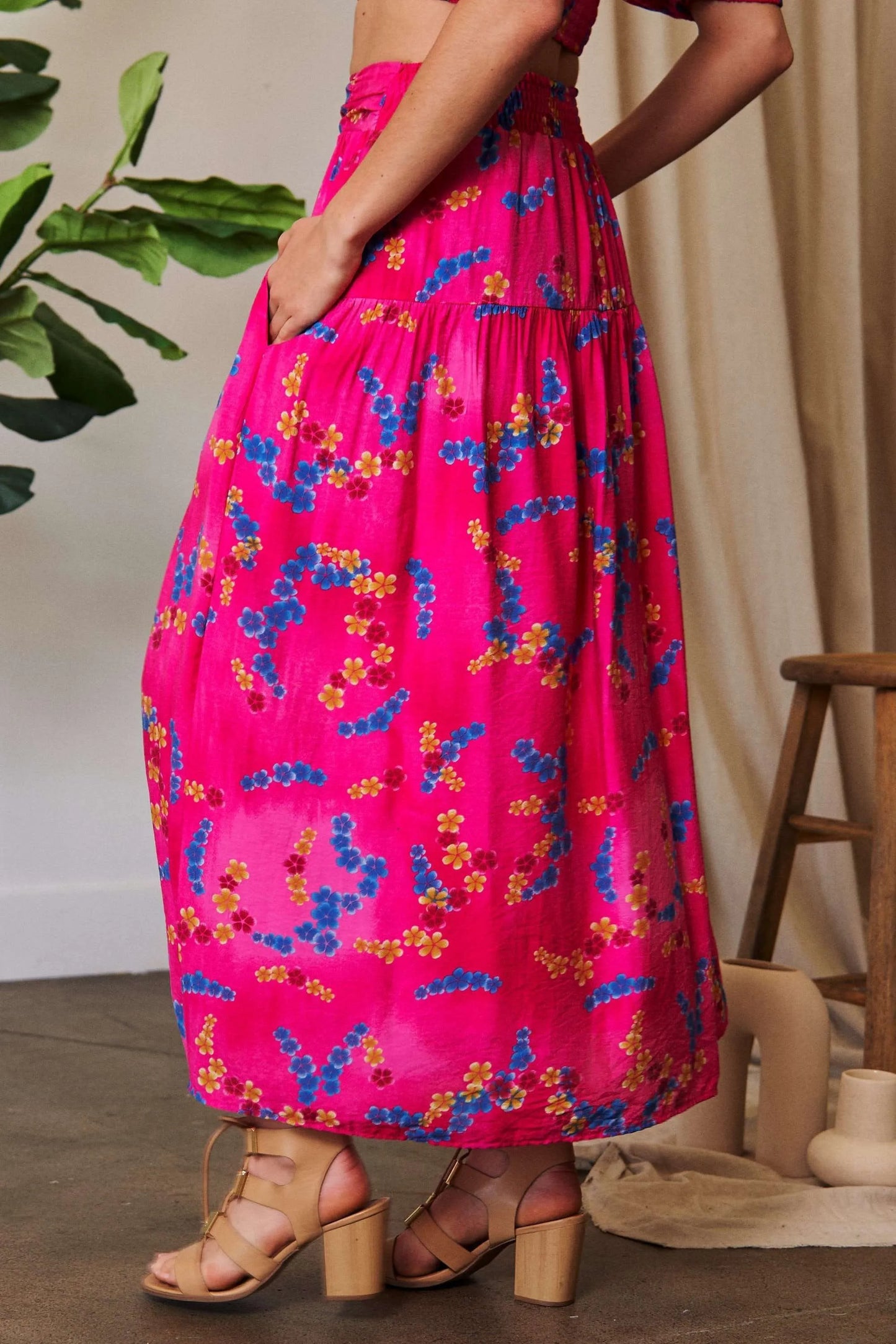 Candy pink Davi & Dani printed smocking waistband ruffled maxi skirt with floral pattern and flowing silhouette.