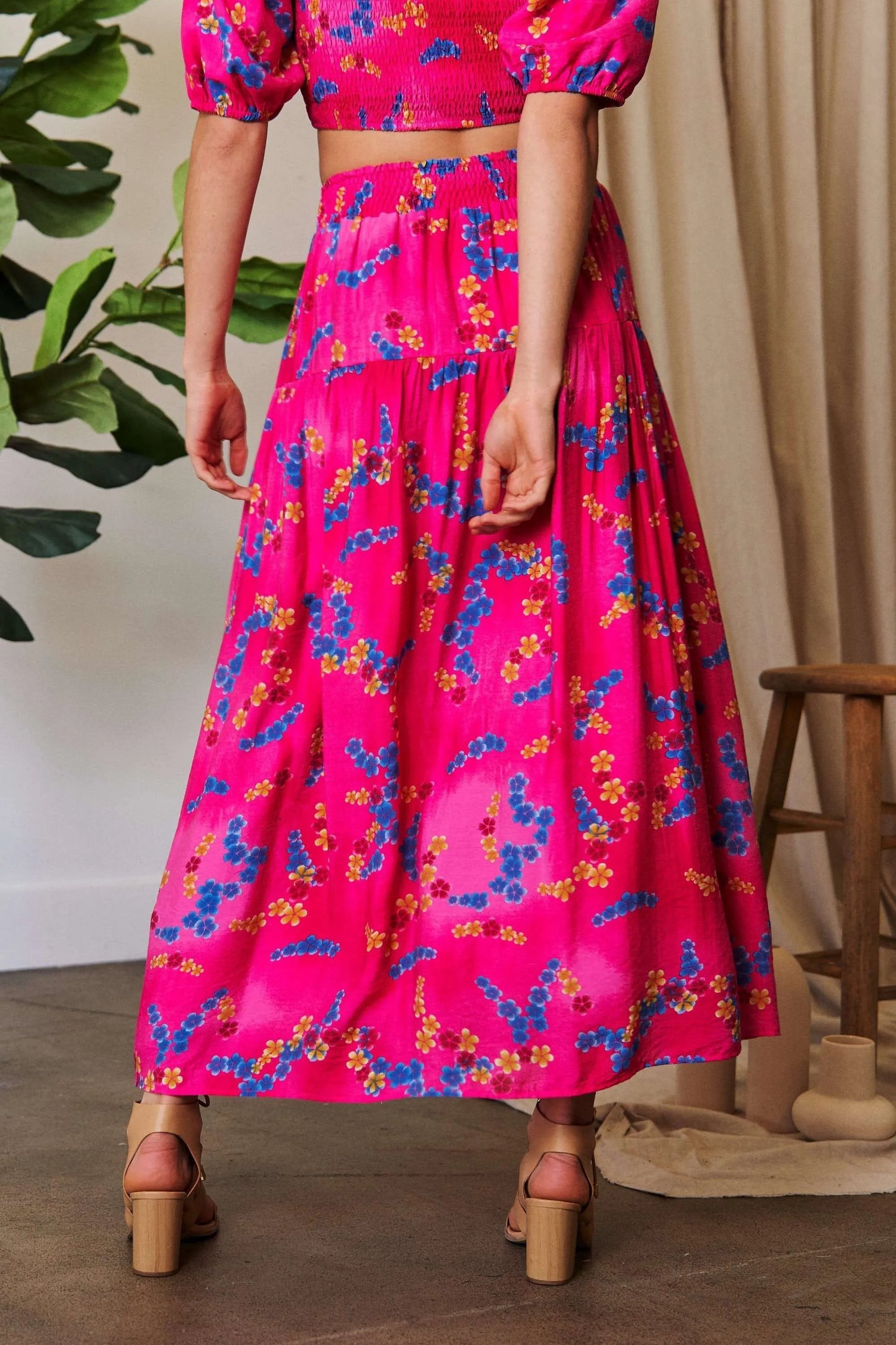 Candy pink Davi & Dani printed maxi skirt with smocking waistband and ruffled hem, perfect for a stylish summer look.