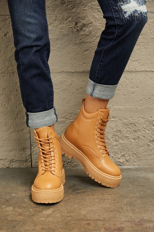 Caramel East Lion Corp platform combat boots with chunky soles and lace-up design, styled for a bold, edgy look.