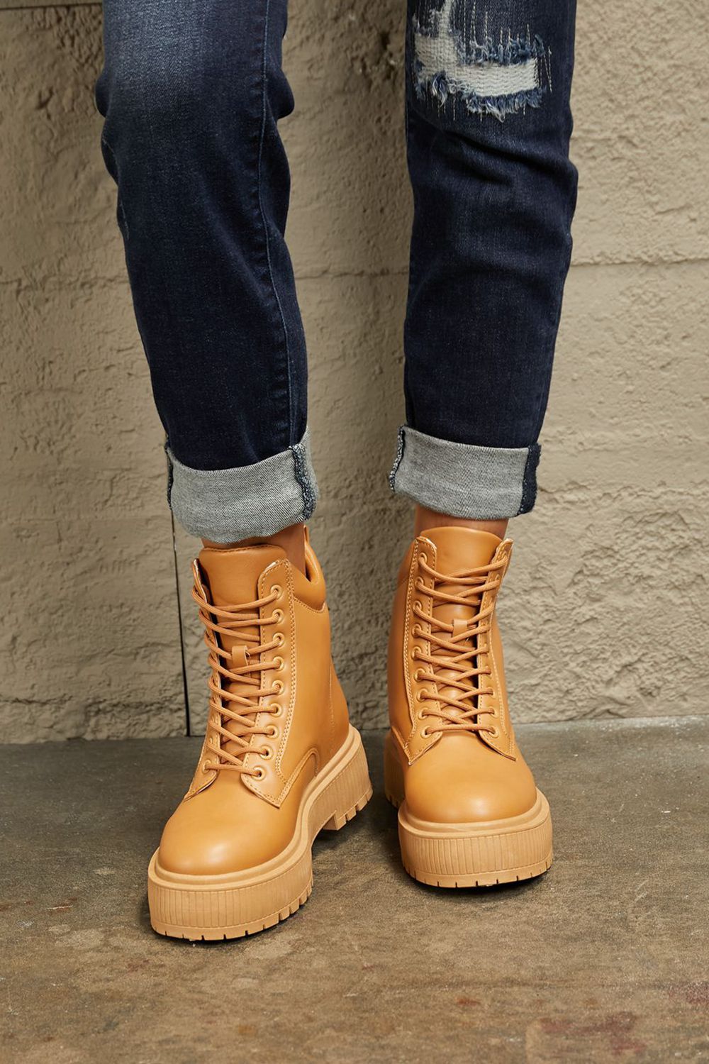 Caramel East Lion Corp platform combat boots with chunky soles and lace-up design, styled for a bold, edgy look.