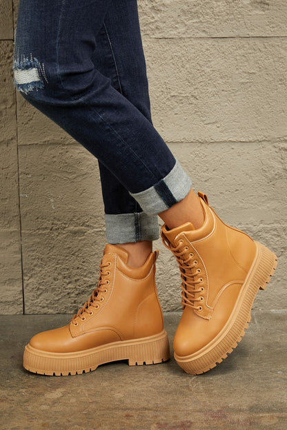 Caramel East Lion Corp platform combat boots with chunky soles and lace-up design, stylish footwear by Trendsi.