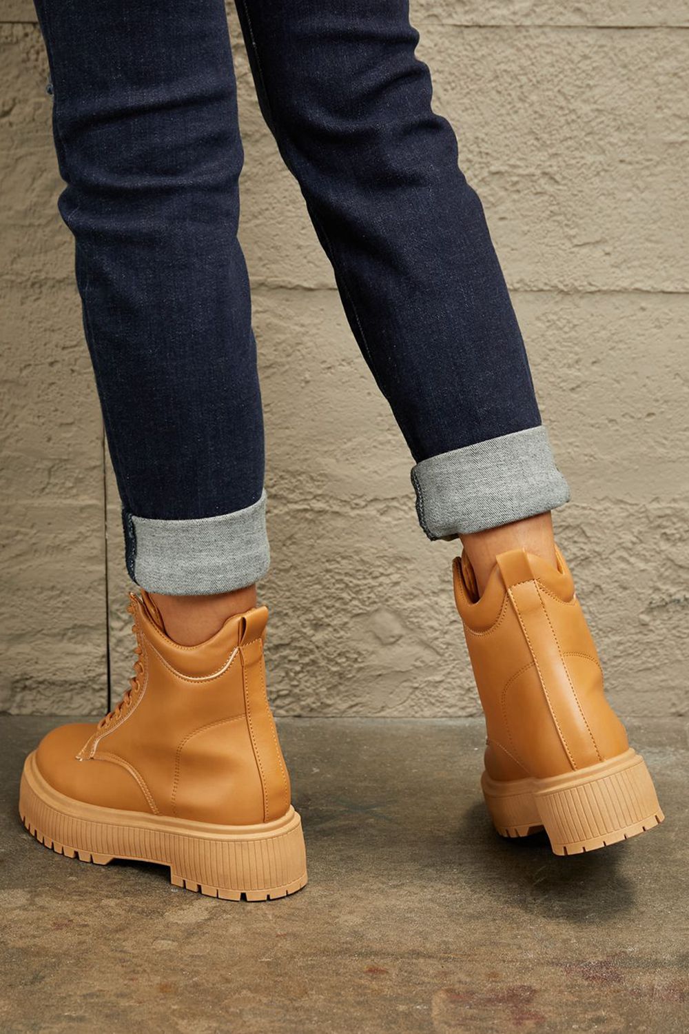 Caramel East Lion Corp platform combat boots with chunky soles and lace-up design, styled for a bold, edgy look.