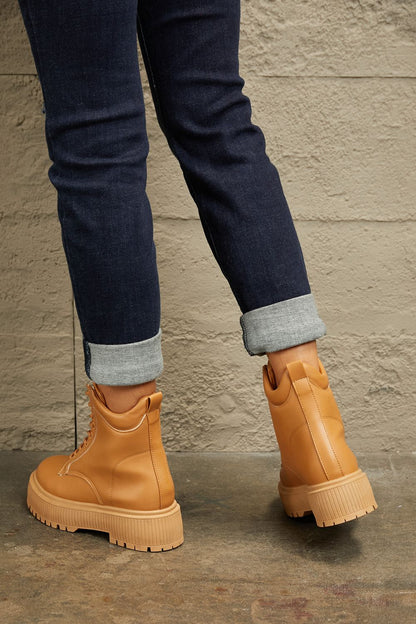 Caramel East Lion Corp platform combat boots with chunky soles and lace-up design, styled for a bold, edgy look.