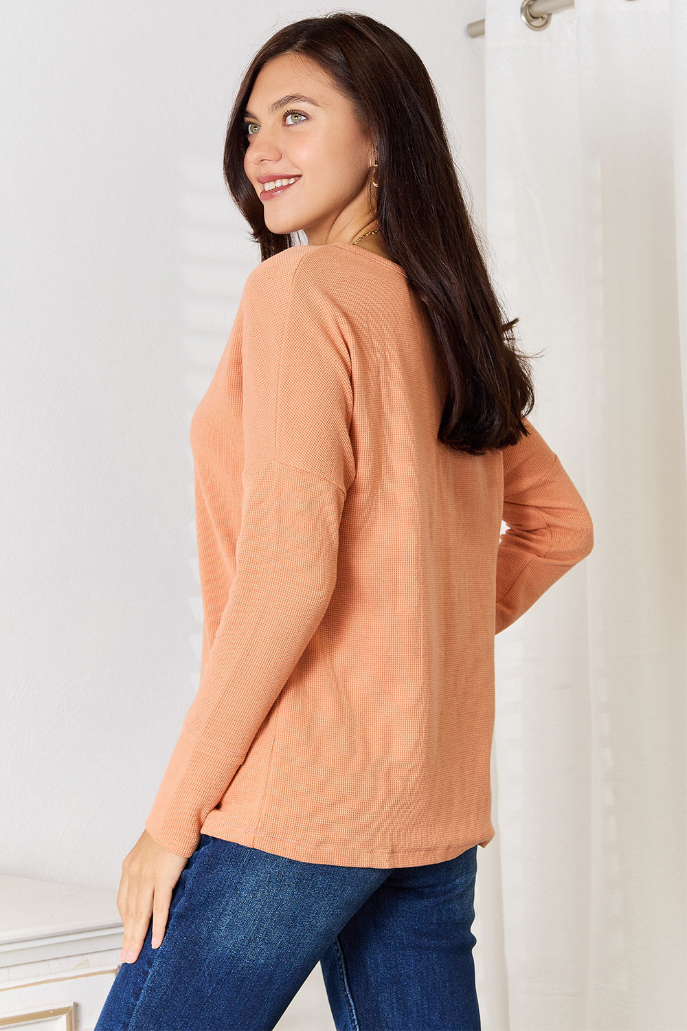 Caramel-colored Basic Bae half-button long sleeve top by Trendsi, featuring a relaxed fit and stylish half-button front.