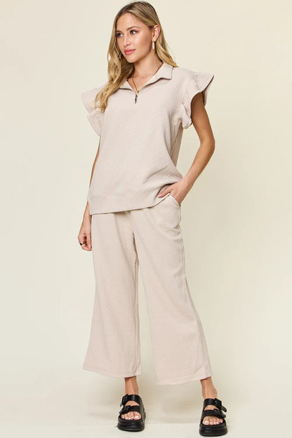Cerulean blue double take texture ruffle short sleeve top with drawstring wide-leg pants set by Trendsi, displayed on a hanger.