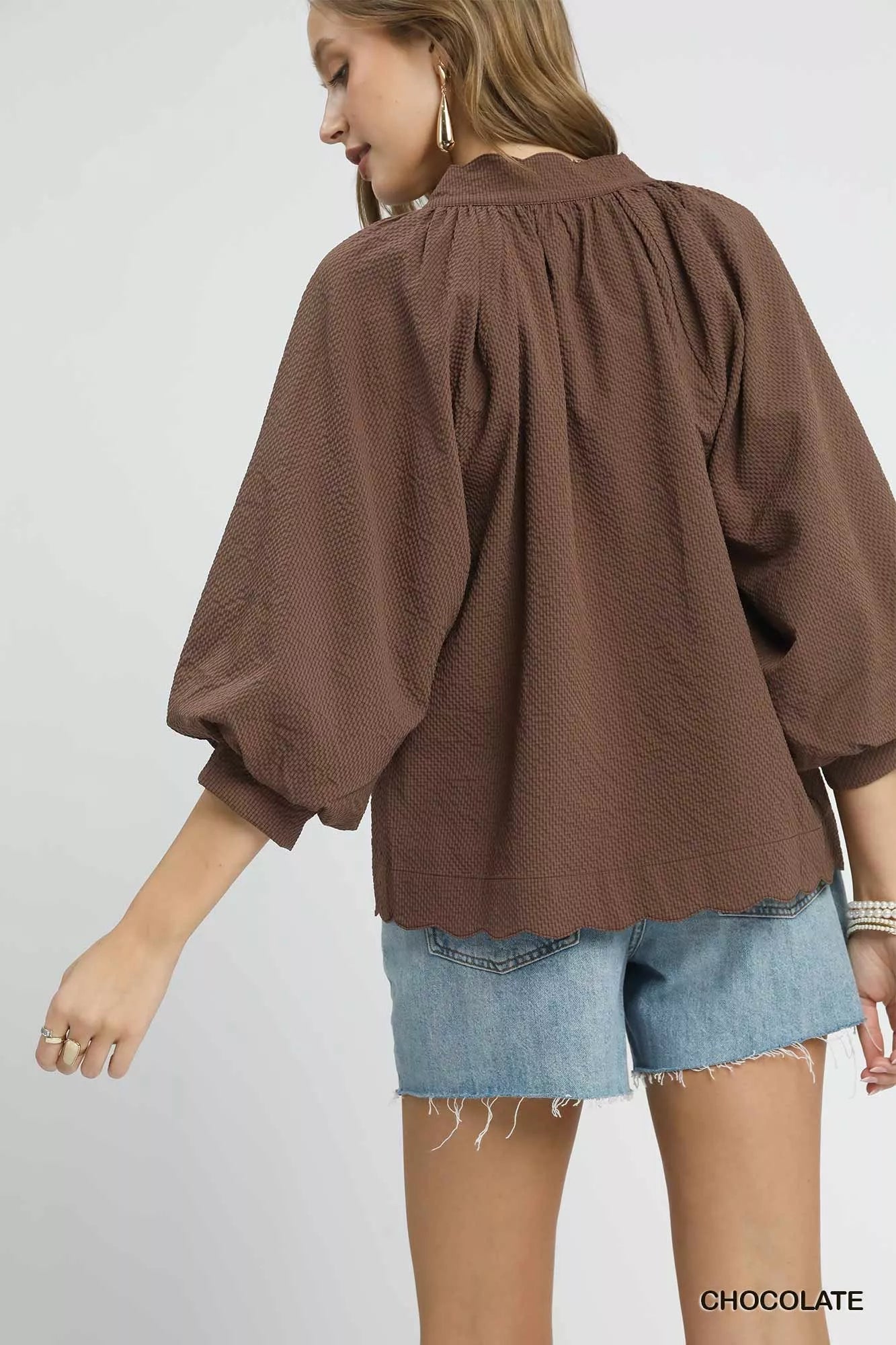 Plus size Umgee textured balloon sleeve blouse with notched details in chocolate color, featuring full-length sleeves and stylish design.