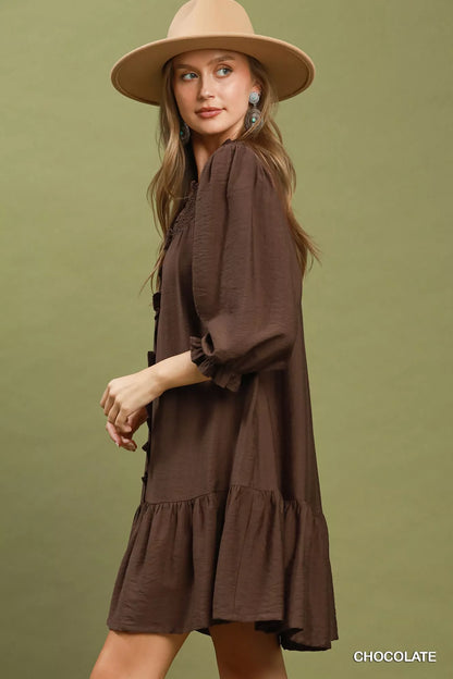 Chocolate brown Umgee smocked ruffle tiered mini dress with feminine details, perfect for casual or semi-formal occasions.