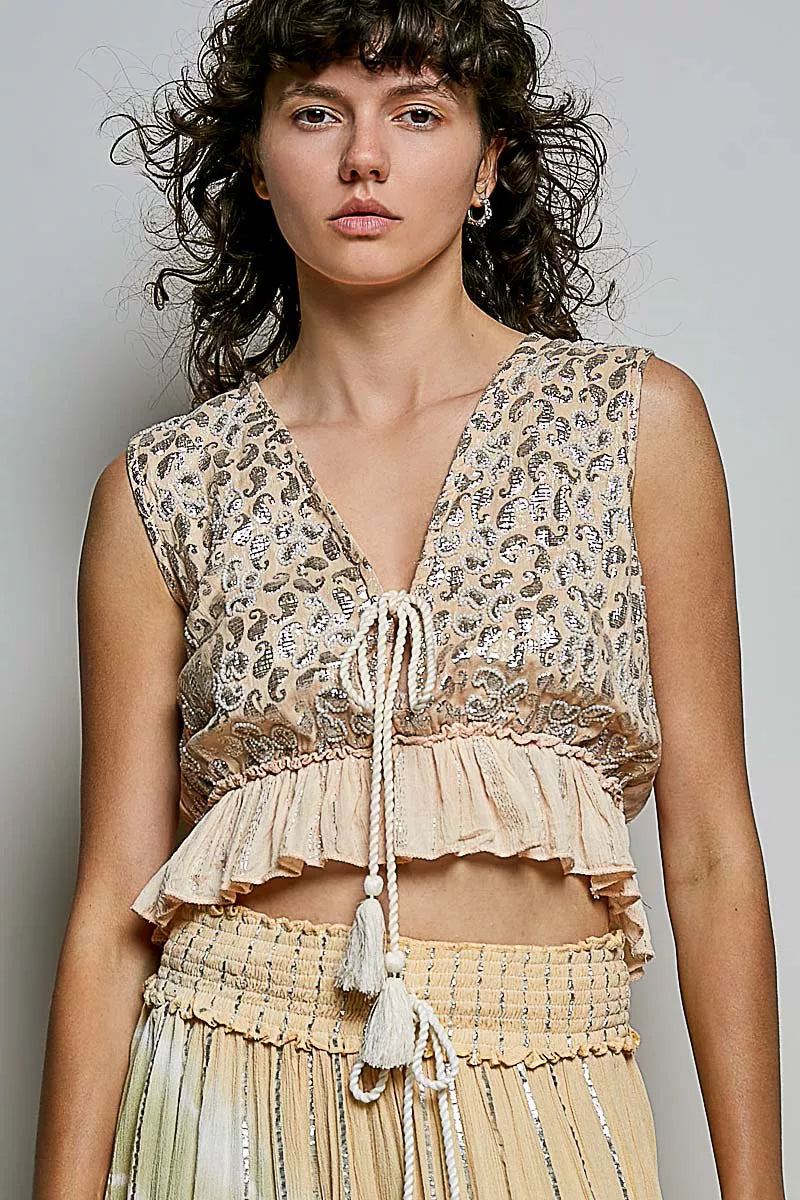 Trendi coral shimmer pattern sleeveless crop top with deep V neckline, tie front, tassel detail, and ruffle hem.