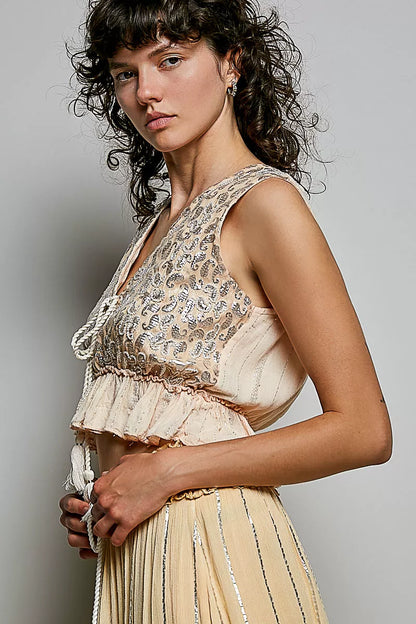 Coral Haze multi-colored shimmer pattern sleeveless crop top with deep V-neck, tie front, tassel accents, and ruffle hem from Trendsi.