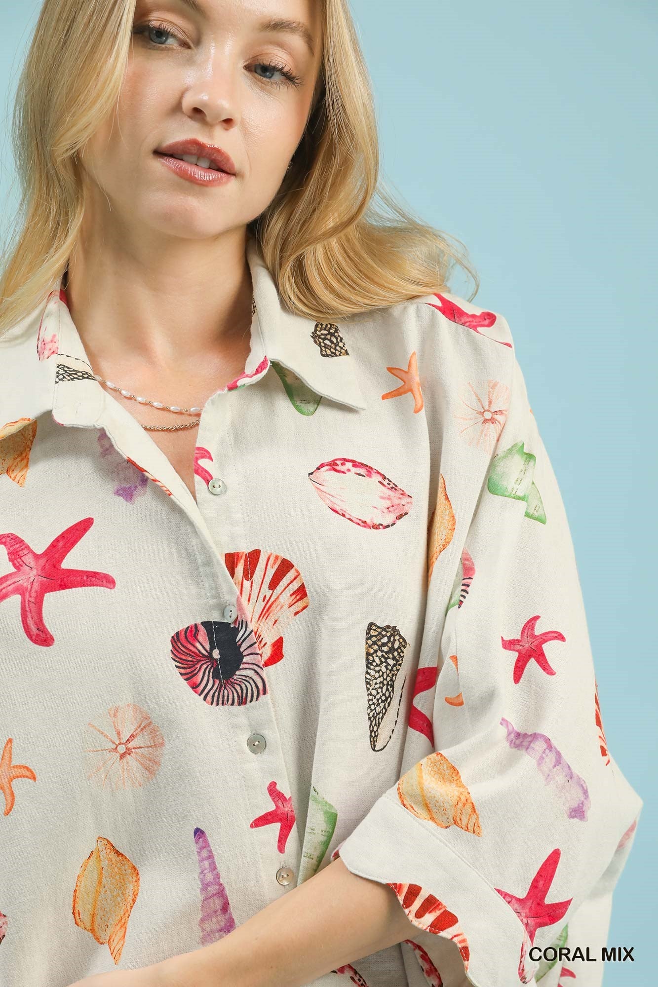 Umgee seashell and starfish print button-down top in coral mix, featuring a casual, ocean-inspired design with long sleeves.