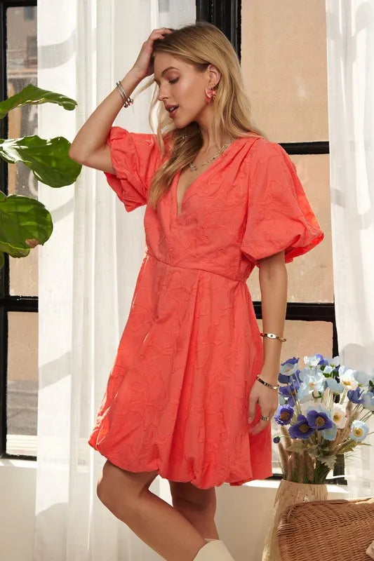 Coral ADORA puff sleeve floral dress by Trendsi featuring a fitted bodice, puff sleeves, and a flowing skirt.