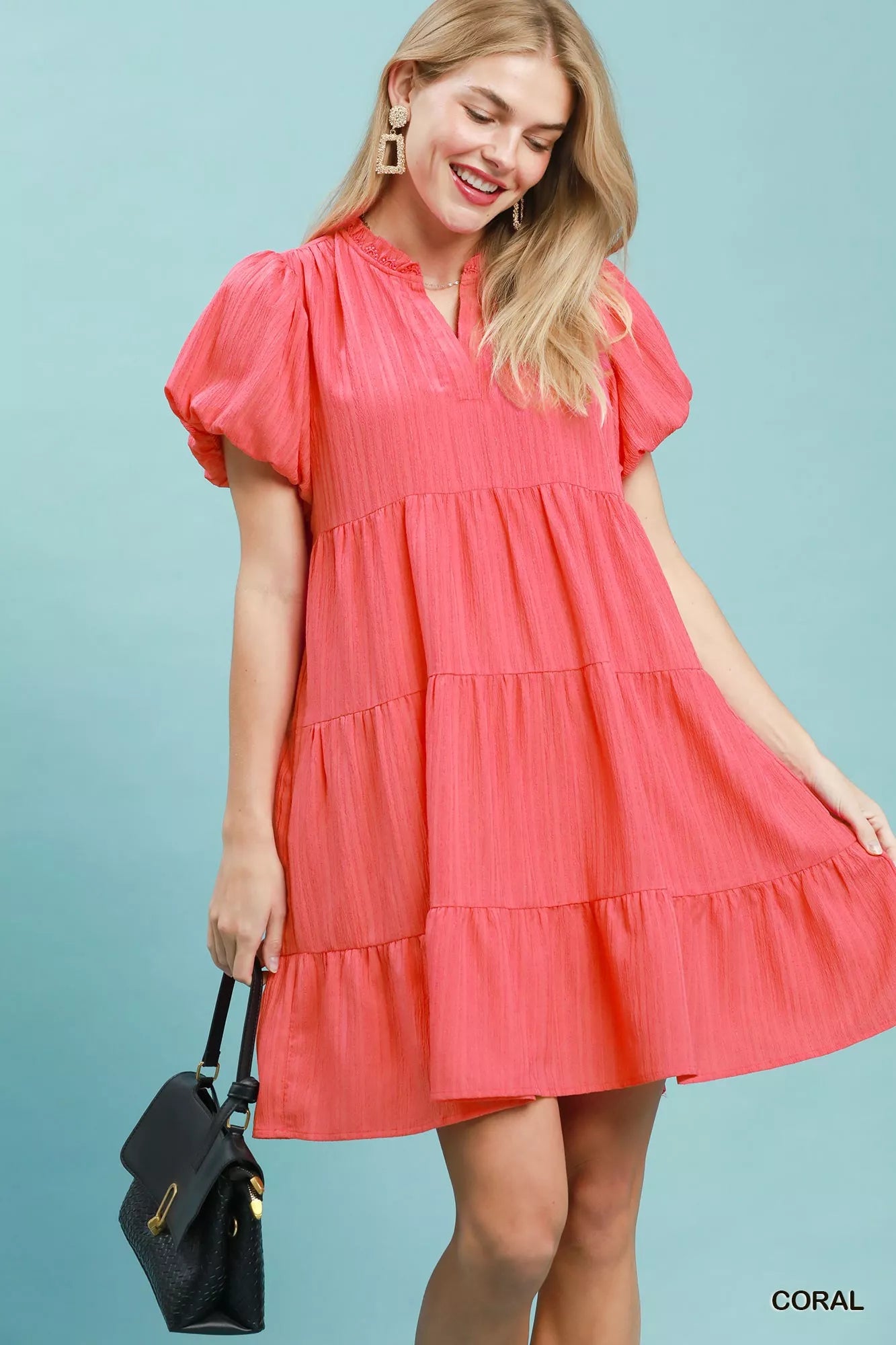 Coral Umgee puff sleeve tiered babydoll dress with a relaxed fit and feminine silhouette, featuring tiered fabric details and a round neckline.