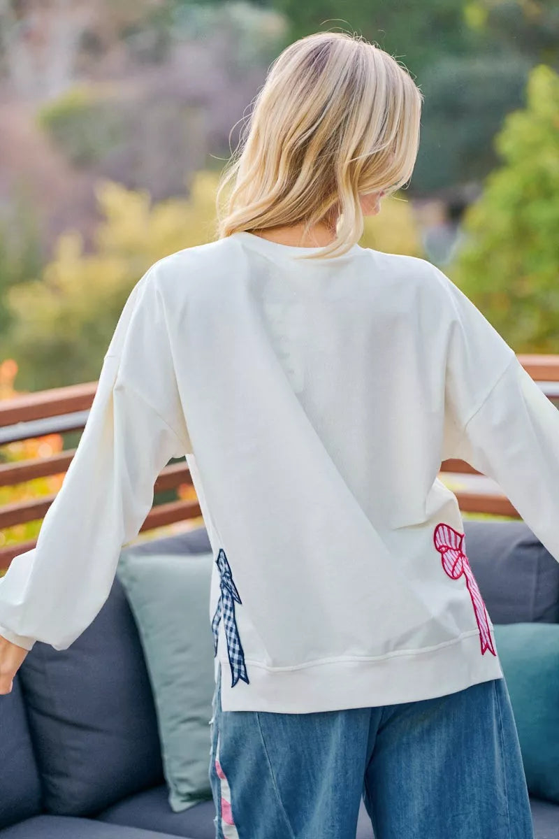 Cream sweatshirt with red, white, and blue stars and stripes patches, featuring the BiBi 4th of July design by Trendsi.